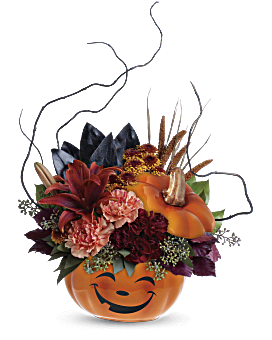 Halloween-themed floral arrangement with pumpkins and dark flowers.