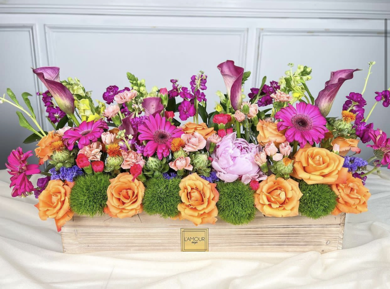 Colorful flower arrangement in wooden box centerpiece.