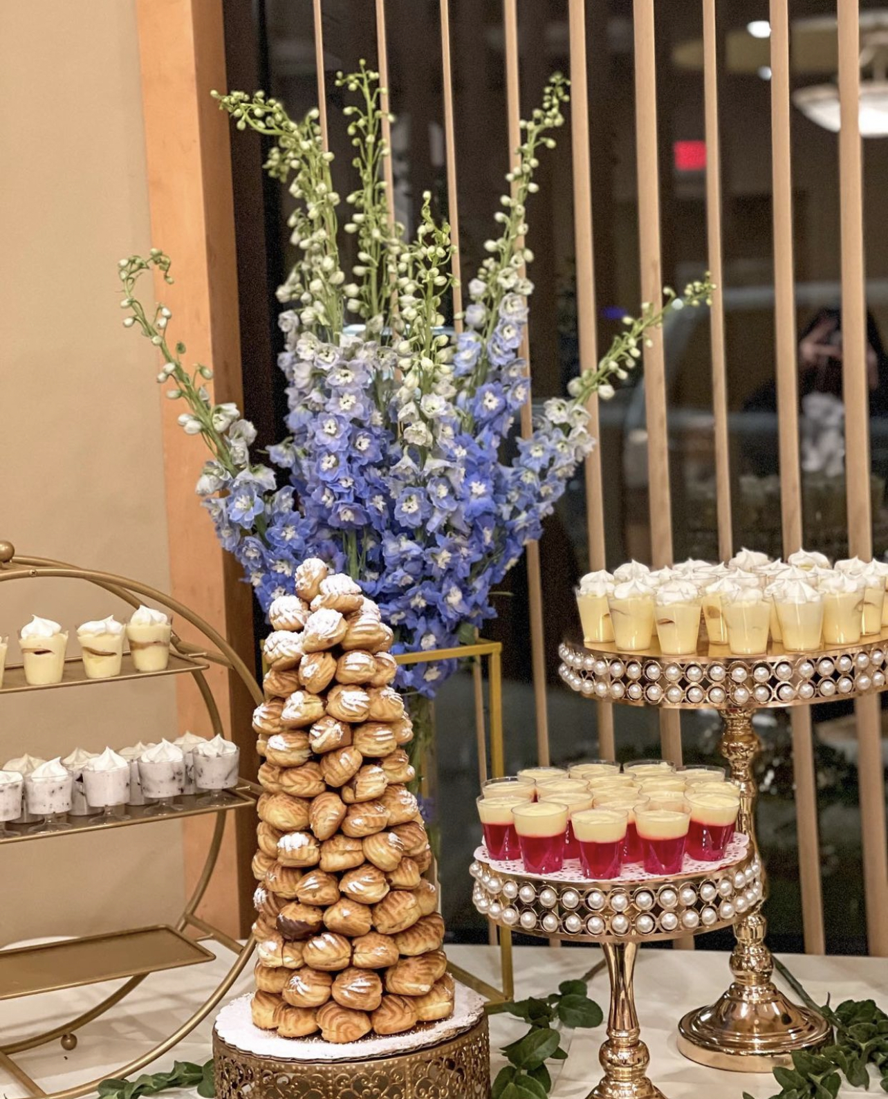 Dessert table with pastries and floral arrangement.