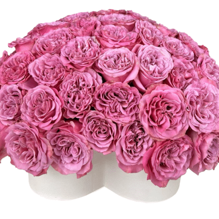 A lavish dome-shaped arrangement composed entirely of pink garden roses, neatly arranged in a tight, symmetrical pattern atop a white heart-shaped hat box. The uniform presentation and rich texture of the ruffled petals create an ultra-romantic, couture floral display—perfect for luxury gifting, love declarations, and unforgettable moments.
